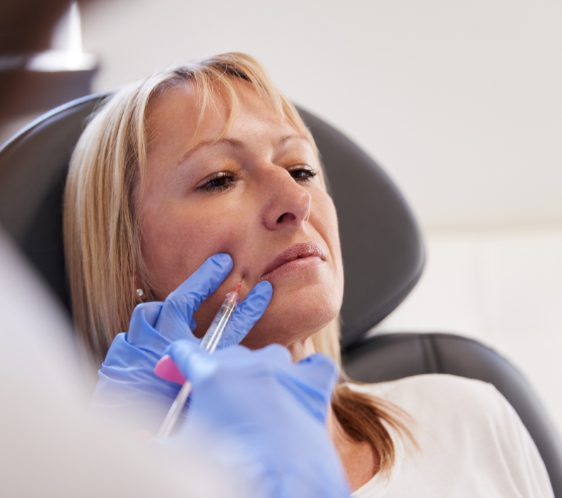 mature woman sitting in chair being give botox inj 2023 11 27 04 52 39 utc